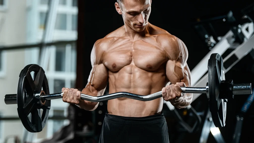 Hombre levantando barra en gimnasio, enfocado en el entrenamiento de fuerza para ganar masa muscular y reducir grasa corporal al mismo tiempo
